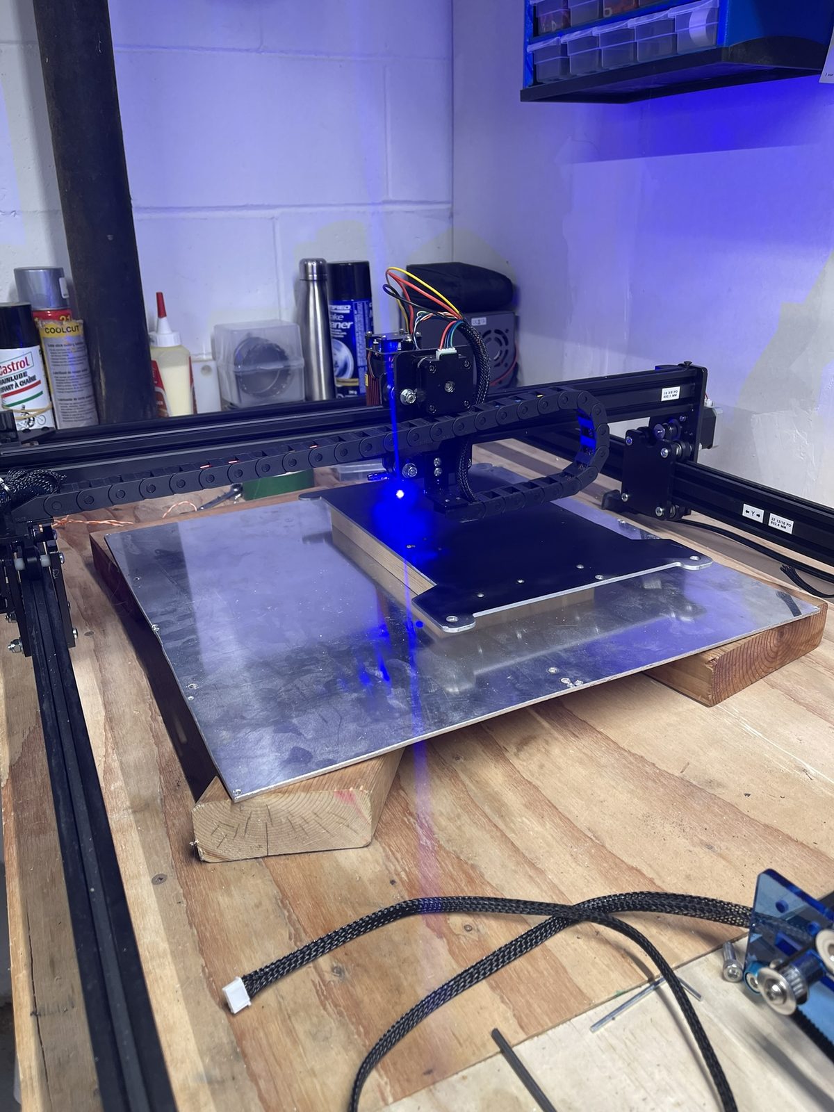 Machine en cours de gravure, faisceau laser bleu allumé sur la plaque de travail